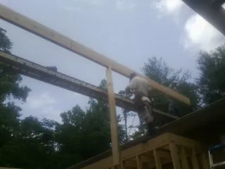 Carpenter setting a ridge beam over a new addition frame — Ice Dam Removal by Roofing Brothers in Yatesboro
