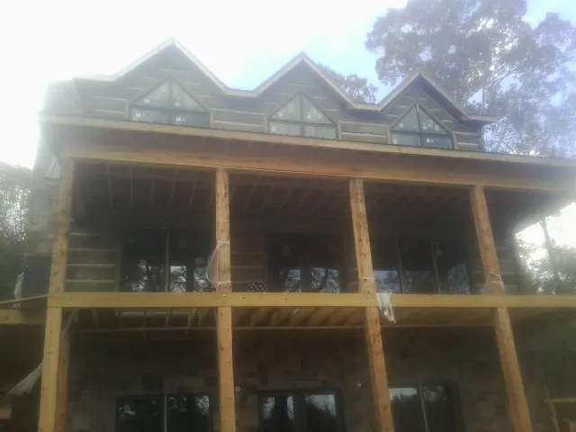 Dormers and porch framing on a large log home under construction — Roof Coating work by our crew in Yatesboro