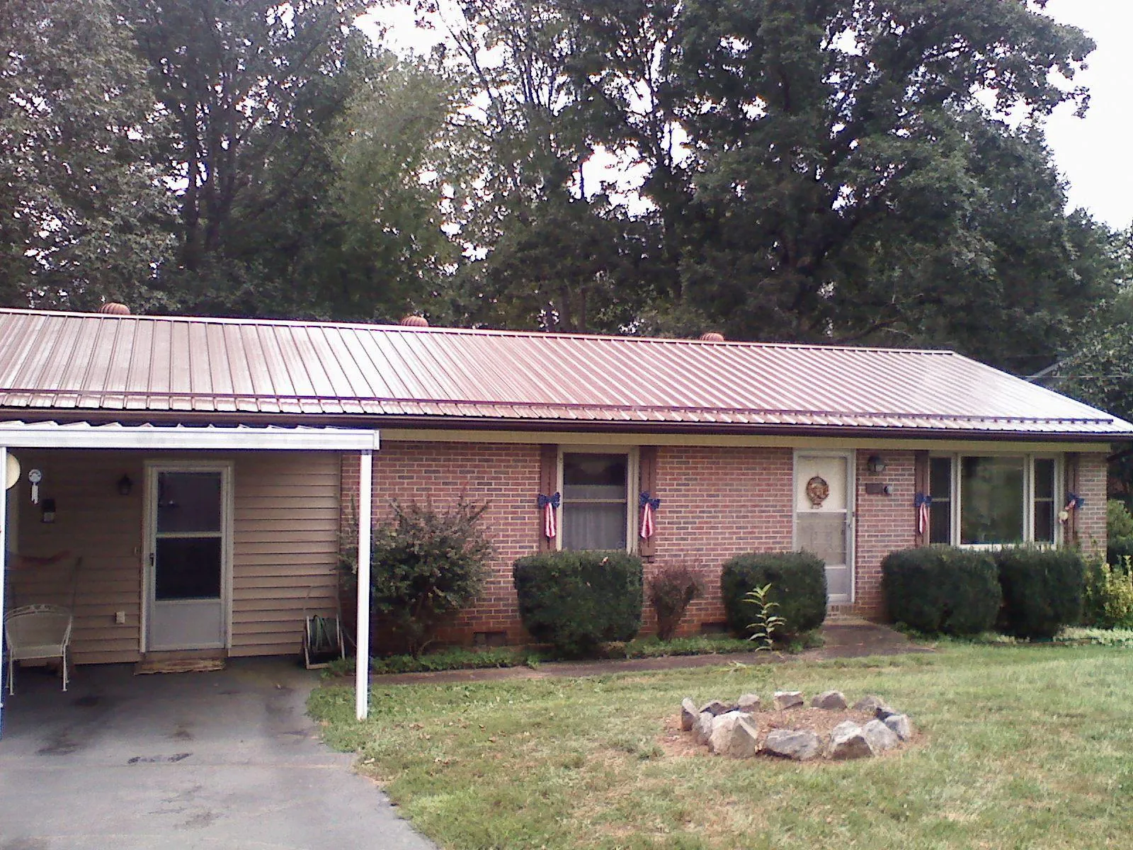 Bronze metal roof and carport on a brick ranch home — Roof Repair work by our crew in Yatesboro
